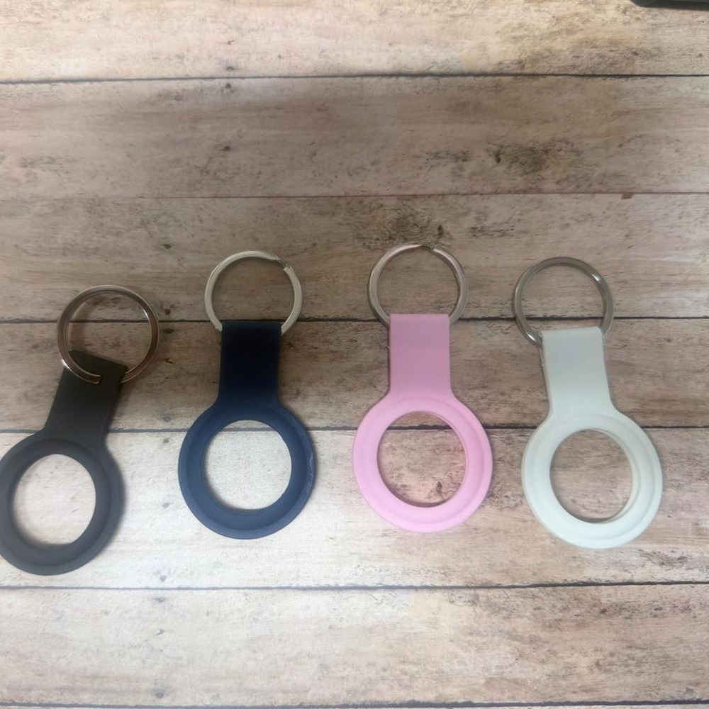 4 Apple Tag keychains cover in white, pink, navy, and black